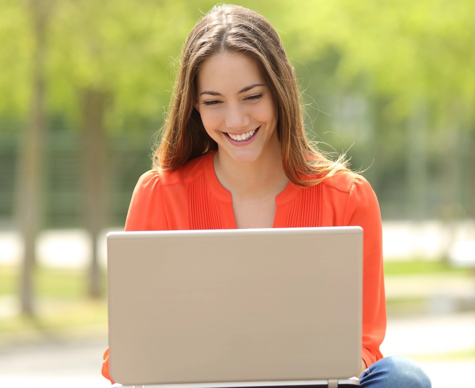 Girl in park on laptop researching JD-Next Admissions Assessment