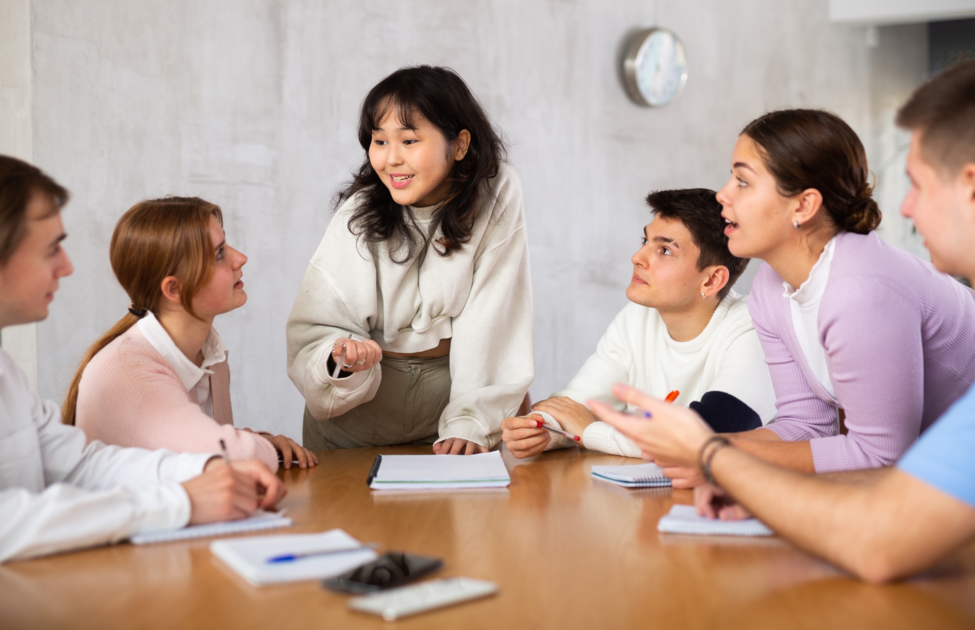 Pre-law students talking at a desk about taking the JD-Next Admissions Assessment